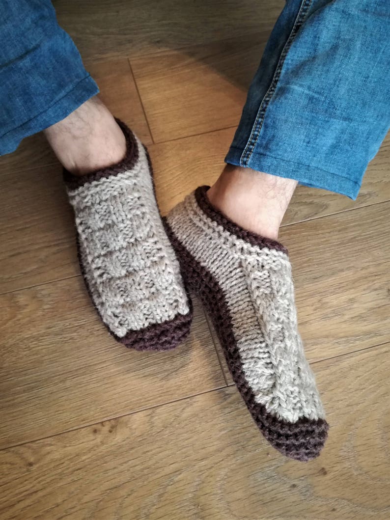 May include: A pair of knitted brown and beige slipper socks with a cable knit pattern.
