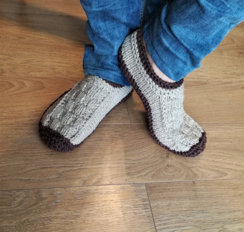 May include: A pair of knitted gray and brown slippers with a cable knit pattern.