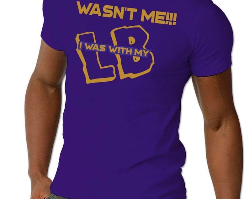 May include: Purple t-shirt with gold lettering that reads "Wasn't Me!!!" and "I Was With My LB".