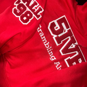 Embroidered old school Line Number Greek Sweatshirt, with school embroidered beneath, and crossing season patch on left sleeve.