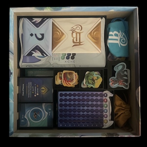 May include: A blue and white game box insert with compartments for storing game pieces, cards, and tokens. The insert has a blue and white pattern and includes a small bag for storing game pieces.