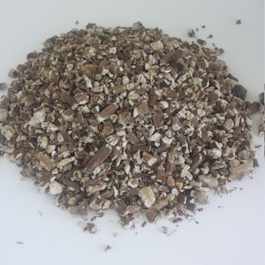 May include: A pile of dried, light brown and tan, chopped burdock root.