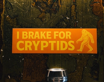I Brake for Cryptids Bumper Sticker | Funny Sasquatch Bigfoot Car Decal | Retro Orange Vinyl Sticker Gift for Monster & UFO Lovers