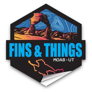Puede incluir: Una pegatina negra y azul con una ilustración colorida de Delicate Arch en el Parque Nacional Arches, Utah. El texto "FINS & THINGS" está en azul y "MOAB • UT" está en blanco.