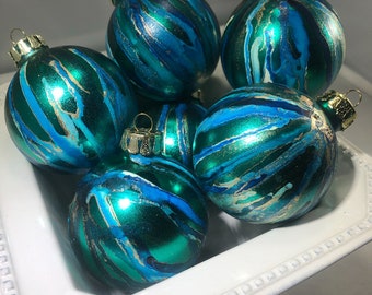 May include: A set of six teal blue Christmas baubles with gold and white abstract swirl designs.