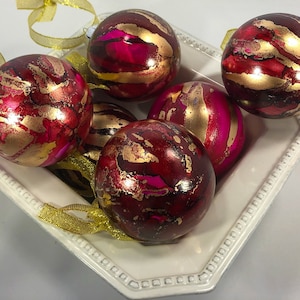 Red, pink and gold alcohol ink Christmas ornaments. SOLD SEPARATELY. Round glass painted Christmas decorations for your tree or table.