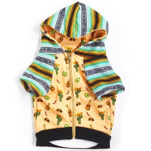 May include: A yellow, green, and black dog hoodie with a zipper closure. The hoodie has a pattern of cacti, avocados, guitars, and sombreros. The sleeves are striped with a green, black, and yellow pattern.