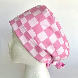May include: Pink and white checkered surgical scrub hat with a tie at the back.