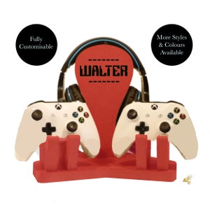 May include: Red gaming console stand with two white controllers and a headset holder. The stand has the name "WALTER" printed on it.
