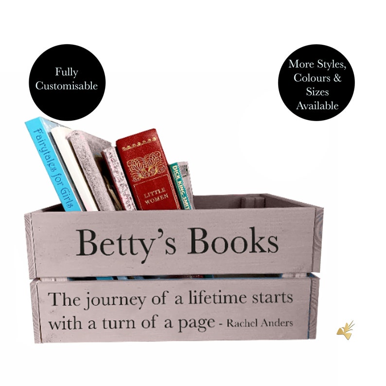 May include: A gray wooden crate labeled "Betty's Books" filled with books, including "Fairytales for Girls" and "Little Women." The crate has the quote "The journey of a lifetime starts with a turn of a page - Rachel Anders."