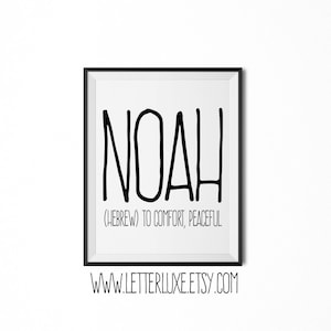 Op de afbeelding: Zwart-witte printbare kunstprint met de naam NOAH in vetgedrukte letters. De tekst (HEBREW) TO COMFORT, PEACEFUL staat onder de naam. De print is ingelijst in een zwart frame.