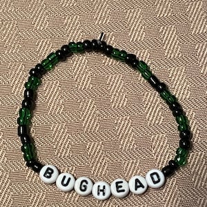 May include: A white ceramic mug with a black handle and the text "But First, Coffee" in a black, bold font. The mug is sitting on a white surface.