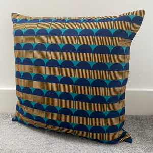 May include: A blue and gold patterned cushion with a geometric design. The cushion is made of a soft, durable fabric and is perfect for adding a touch of style to any room.