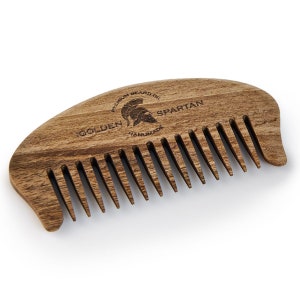 May include: A wooden comb with a Spartan helmet logo and the text "Golden Premium Beard Oil Handmade Spartan".