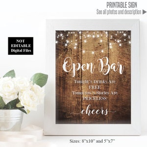 Puede incluir: Señal imprimible con un fondo de madera rústica y luces de cadena. La señal dice "Open Bar" e incluye el texto "Las bebidas de esta noche son gratis. Las historias de mañana no tienen precio. ¡Salud!" La señal está disponible en dos tamaños: 8x10 pulgadas y 5x7 pulgadas.
