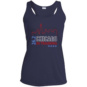May include: Navy blue athletic tank top with a white and red Chicago skyline graphic. The text reads "26.2 CHICAGO IN TRAINING" with four blue stars. A racerback style top, perfect for running or workouts.
