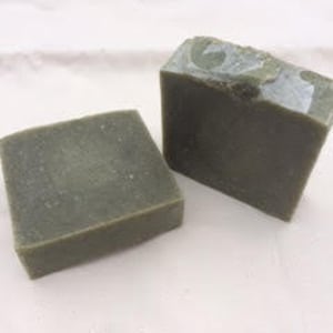 May include: Two bars of handmade green soap. The soap is a light green color with a mottled appearance.