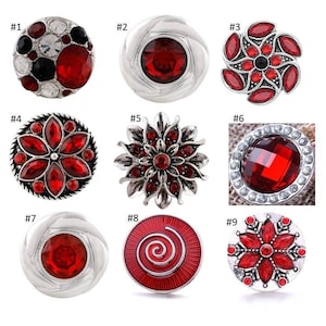 May include: Nine red and silver snap buttons with various designs, including a swirl, a flower, and a geometric pattern.