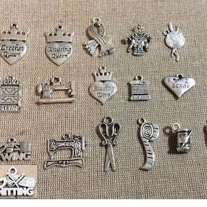 May include: A collection of 15 silver charm pendants with various sewing and knitting themes. The charms feature words like "Crochet Queen", "Knitting Queen", "I Love Quilting", "Beading Diva", "I Love Sewing", and "I Love Knitting".
