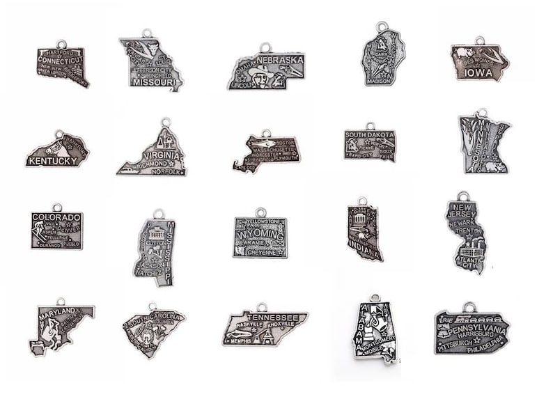 May include: A set of 18 silver charm pendants shaped like the outlines of different US states. Each state has its name and a city or landmark printed on it.