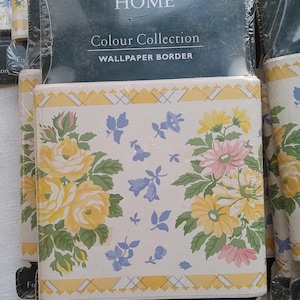 May include: A roll of Laura Ashley Home wallpaper border with a floral pattern in yellow, pink, and blue on a white background. The border has a yellow and white checkered pattern along the bottom. The packaging says "Colour Collection Wallpaper Border" and "For coordinating Laura Ashley Paints see reverse."