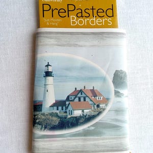 May include: Sunworthy PrePasted Borders with a coastal lighthouse scene. The package includes 8.4 sq. ft. of pre-pasted wallpaper border, measuring 5 yards by 6.75 inches. The border features a lighthouse, houses, and ocean view.