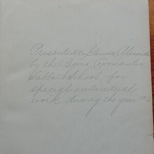 May include: A light-colored page from a book featuring handwritten cursive text that reads: Presented to Geneva Alexander by the Regina Covenanter Sabbath School, for special individual work during the year 1916.