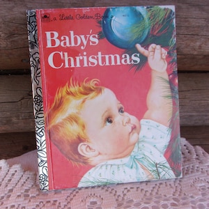 May include: A vintage "Baby's Christmas" Little Golden Book. The cover features a baby reaching for a blue Christmas ornament. The book has a red background with the title in white. The spine is silver with a floral design.