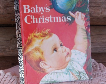 May include: A vintage "Baby's Christmas" Little Golden Book. The cover features a baby reaching for a blue Christmas ornament. The book has a red background with the title in white. The spine is silver with a floral design.