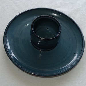 May include: A dark blue ceramic plate with a smaller dark blue ceramic bowl in the center.