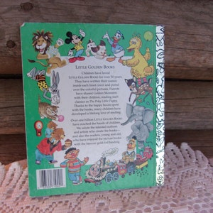 May include: Back cover of a Little Golden Book featuring illustrations of various cartoon characters, including Mickey Mouse, Donald Duck, and Big Bird. The book has a green border with text that reads "LITTLE GOLDEN BOOKS".