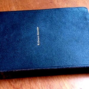 May include: A dark blue rectangular book with a textured cover. The name R. Geneva Alexander is embossed in gold lettering on the front center of the cover. The book has a hard binding and a slightly worn edge along the right side of the cover.
