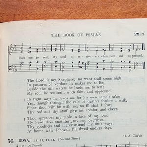 May include: A page from a hymnal titled The Book of Psalms, featuring musical notation on a staff with lyrics including The Lord is my Shepherd; no want shall come nigh. The text is printed in black ink on white paper, with the composer H. A. Clarke listed.
