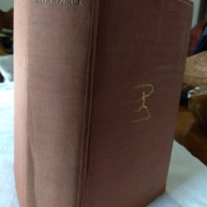 May include: A vintage hardcover book titled "Tom Jones" by Fielding. The book has a brown cover with gold lettering on the spine and a gold illustration on the front. The book is in good condition.