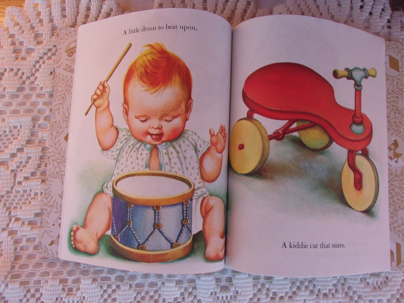May include: Illustration from a children's book featuring a baby playing a drum and a red tricycle. The baby is depicted with rosy cheeks and a happy expression, holding drumsticks. The tricycle has yellow wheels.