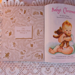 May include: Open vintage book titled "Baby's Christmas" by Esther Wilkin, illustrated by Eloise Wilkin. The cover features a baby holding a teddy bear. The inside cover has a decorative pattern and a space to write the owner's name.