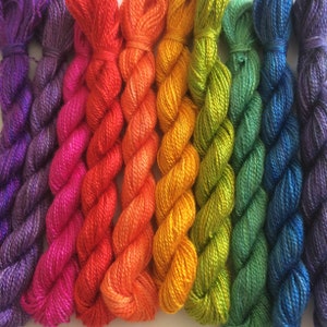 Peut inclure: Assortiment de fils à broder arc-en-ciel, avec des couleurs allant du violet au bleu, vert, jaune, orange, rouge et rose.