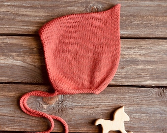 Coral red pointy bonnet for baby, hand knitted with soft pure merino wool