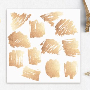 May include: A set of 10 gold foil brushstrokes on a white background. The brushstrokes are in various shapes and sizes, and they have a textured, metallic look.