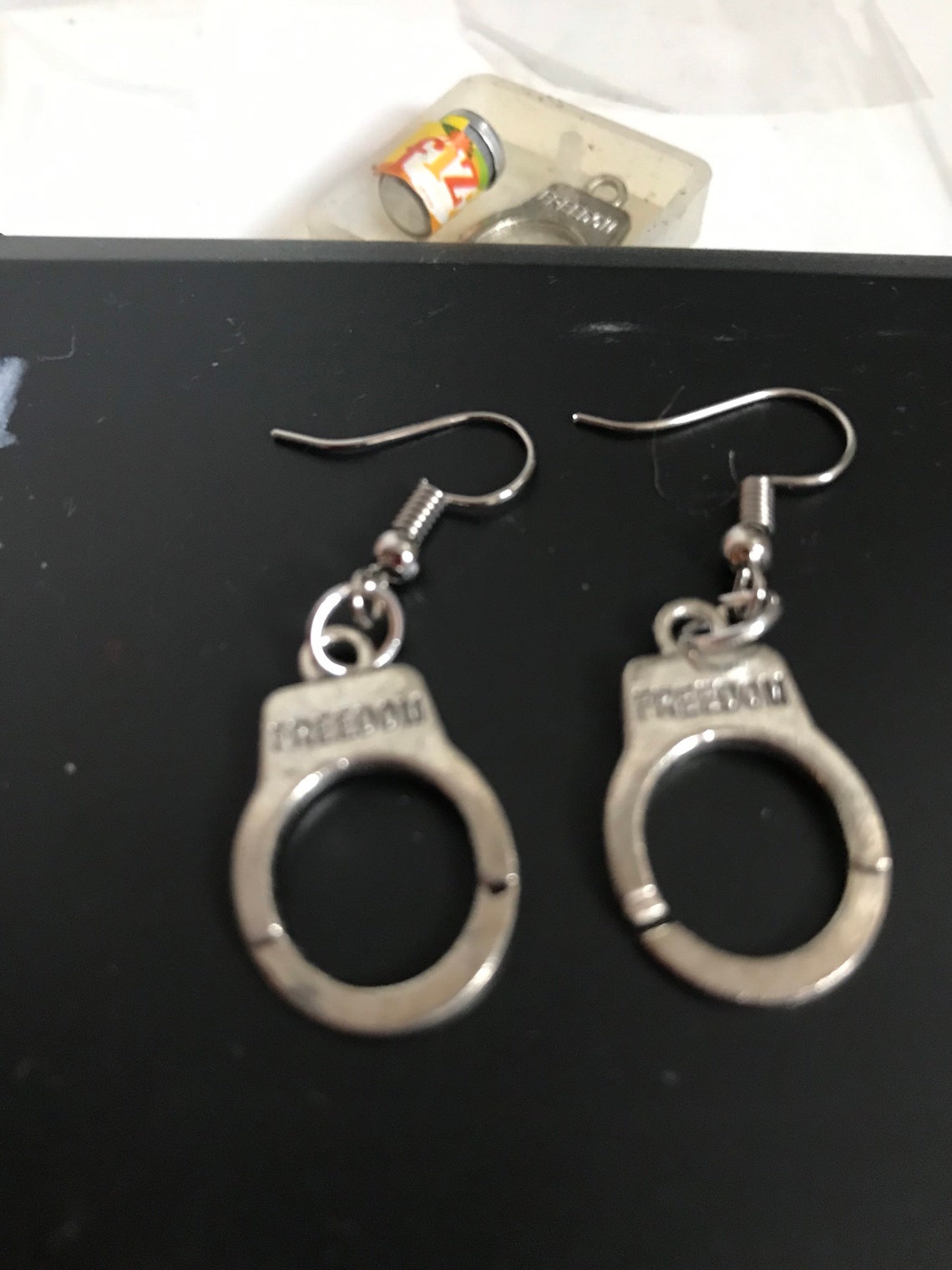 Mini silver handcuff earrings that say freedom on them Etsy