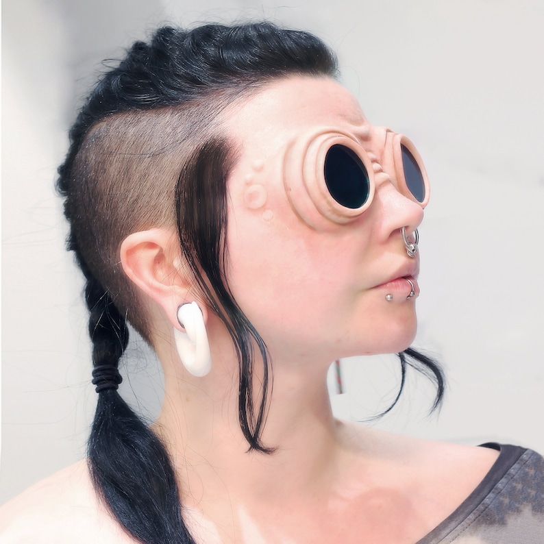 Woman with dark hair wearing silicone steampunk goggles