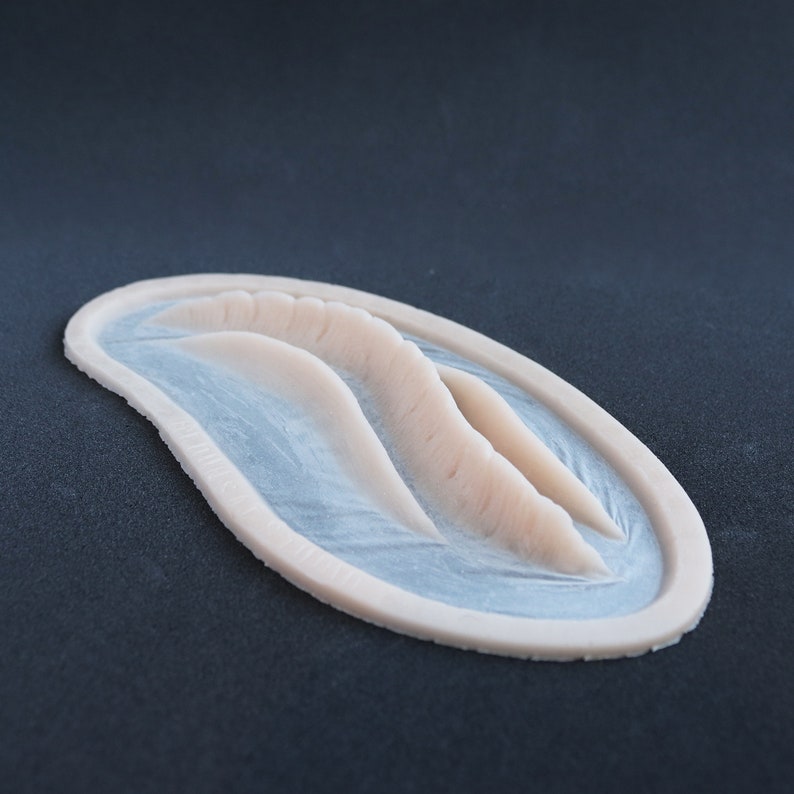 Mermaid Gills silicone prosthetic in vanilla shade on a black surface at a steep angle