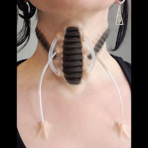 Neck with a cyborg prosthetic with black makeup