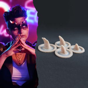 Puede incluir: Cuatro prótesis en forma de cuerno cónico de color blanco roto con bases circulares. Cada pieza presenta una punta curva y lisa que se eleva desde una base plana en forma de disco. Los artículos están dispuestos en grupo, mostrando su color pálido.
