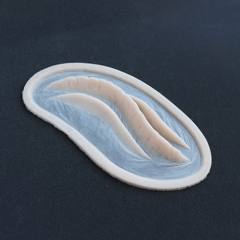 Mermaid Gills silicone prosthetic in vanilla shade on a black surface at an angle