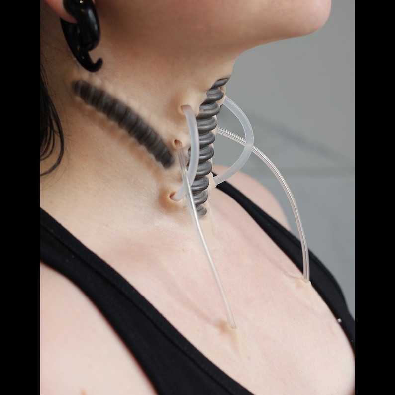 Neck with a cyborg prosthetic and black makeup