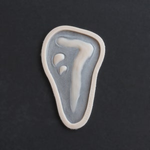 Peut inclure: Un moule en céramique blanc en forme de main avec un motif en relief du chiffre sept à l'intérieur.