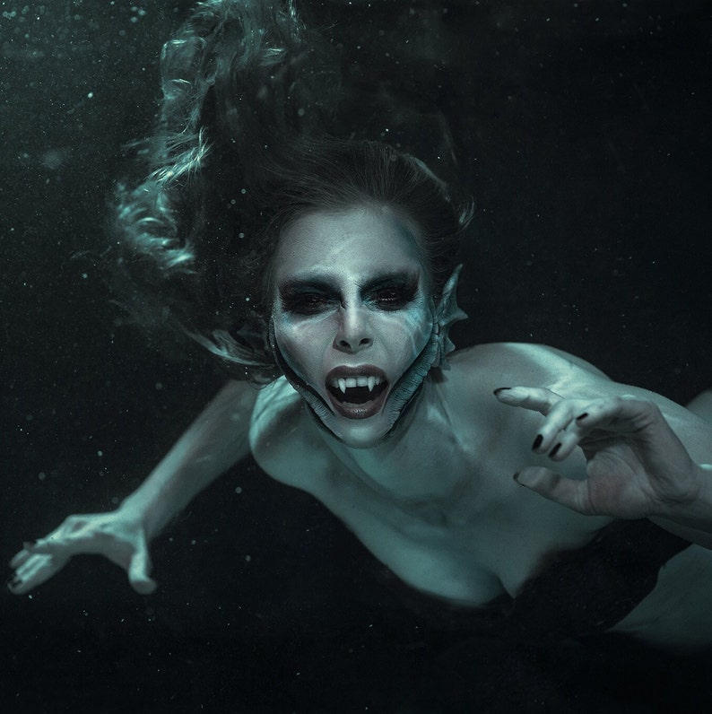 Dark underwater mermaid wearing Mermaid gills prosthetics along her jaw