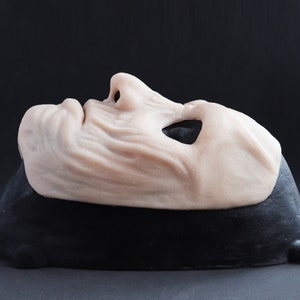 Ghoul Mask in vanilla shade on a black surface at a steep angle