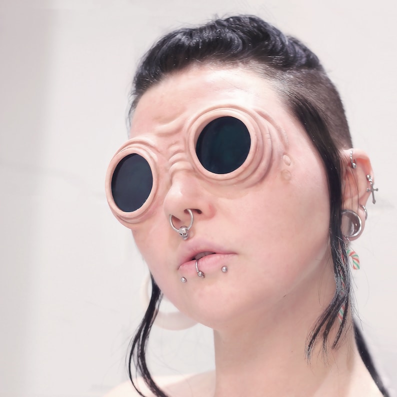 Woman with dark hair wearing silicone steampunk goggles